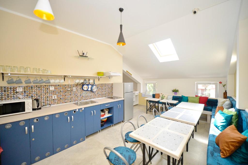 a kitchen and living room with blue cabinets and tables at Hostel Pupa in Kotor