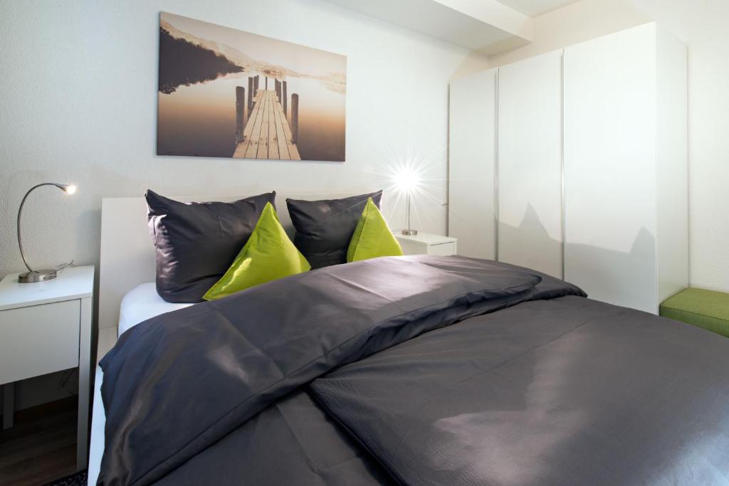フリードリヒスハーフェンにあるVilelo Ferienwohnenのベッドルーム1室(黒と黄色の枕が付いたベッド1台付)