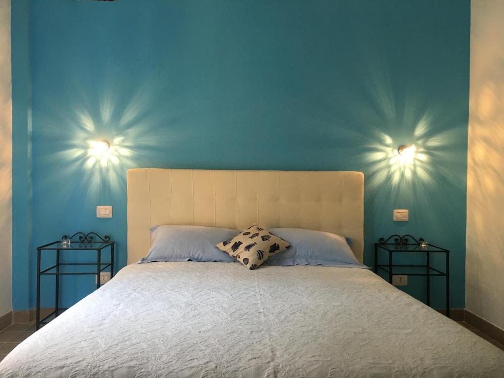a bedroom with a bed with blue walls and two end tables at Albamare in Monterosso al Mare
