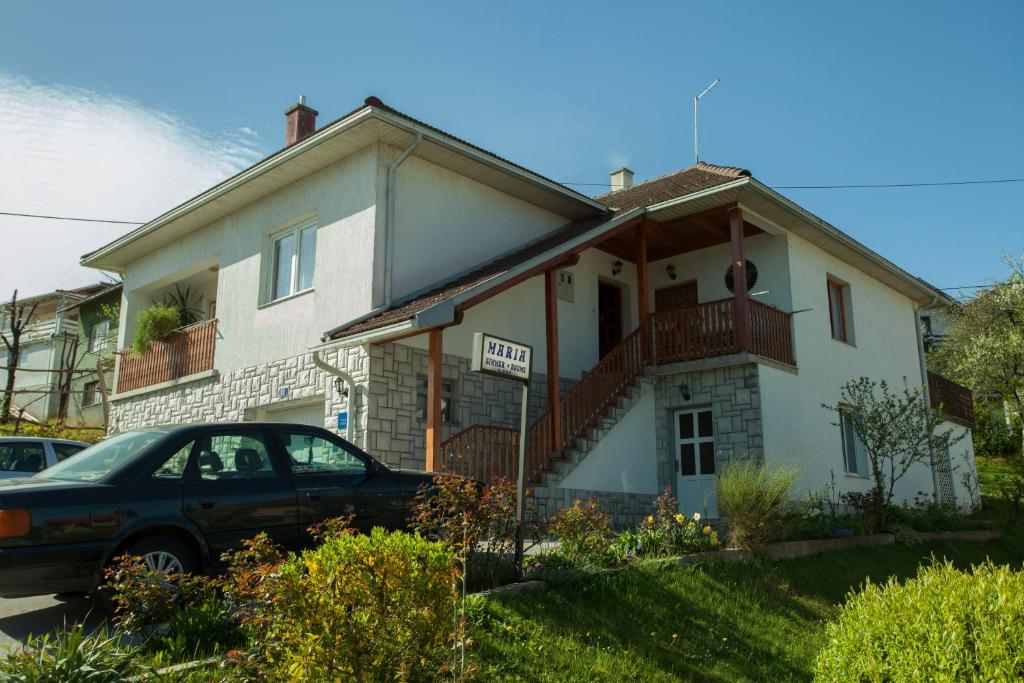 une maison avec une voiture garée devant elle dans l'établissement Rooms Maria, à Slunj