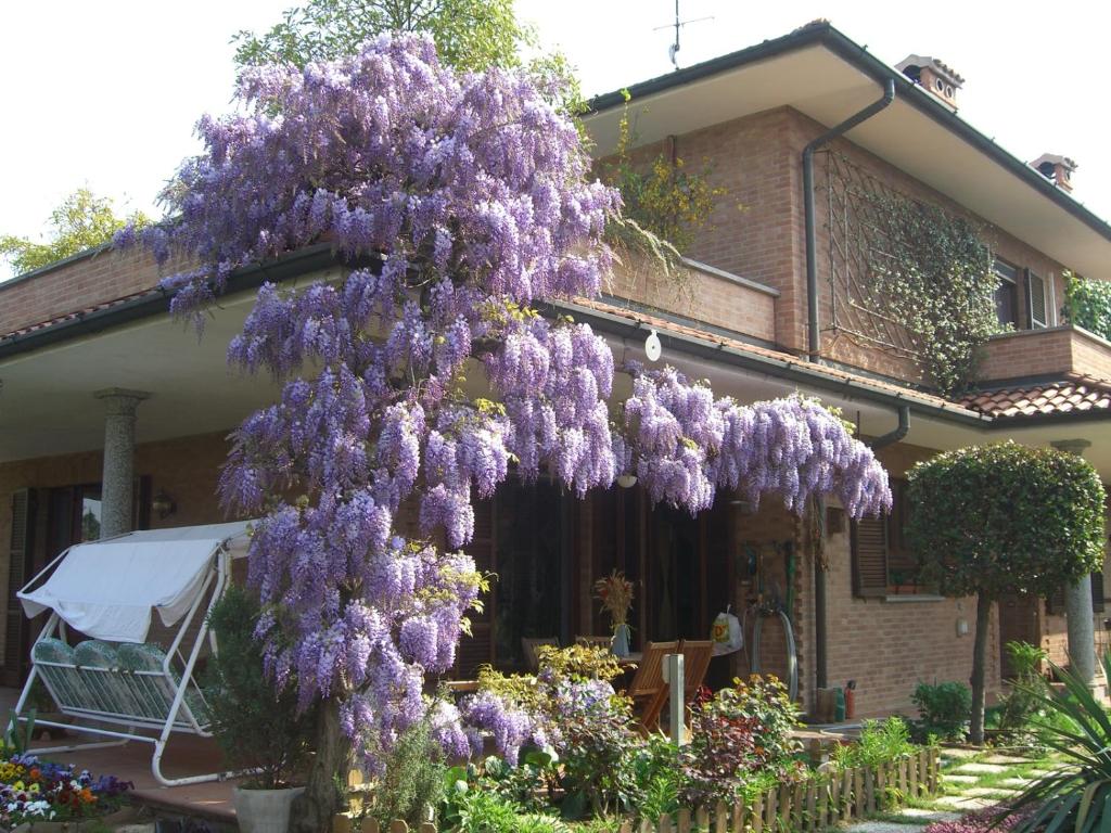 una corona de flores púrpuras colgando de un edificio en B&B Les Fleurettes, en Lomazzo