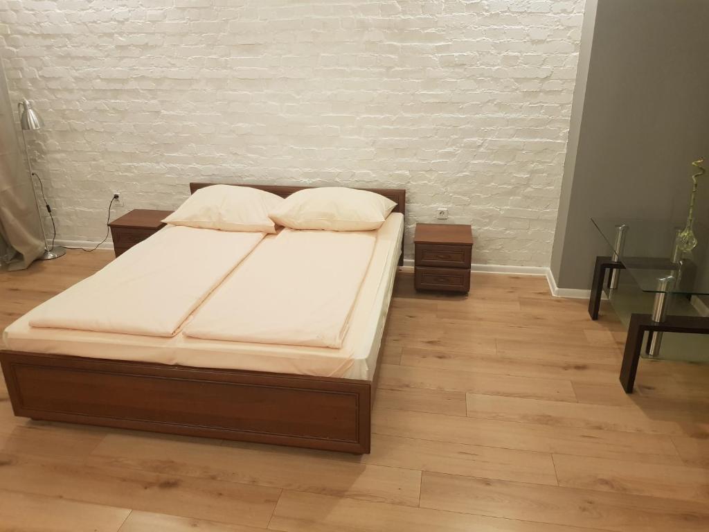 a bed in a room with a wooden floor at Kaktus Guest House in Katowice