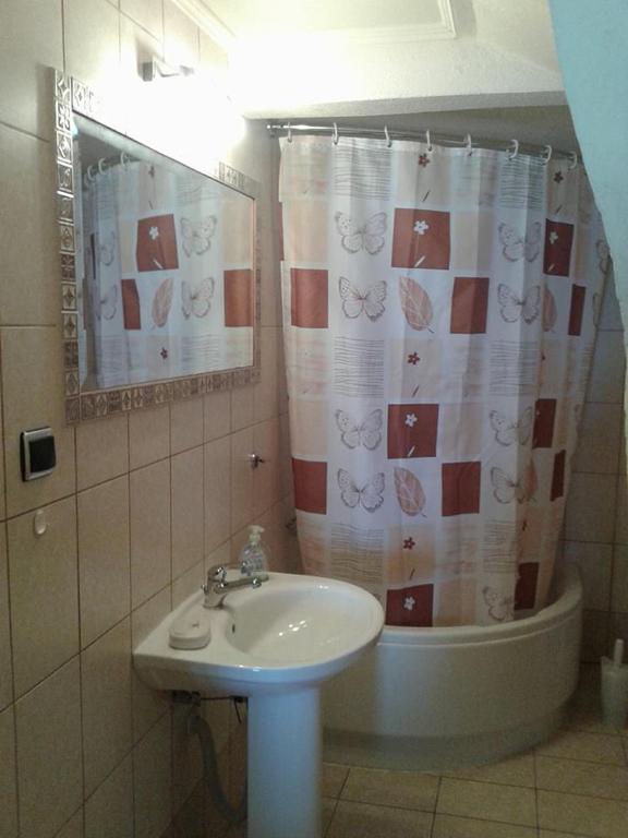 łazienka z umywalką i zasłoną prysznicową w obiekcie Gatos Apartment w mieście Skala Marion