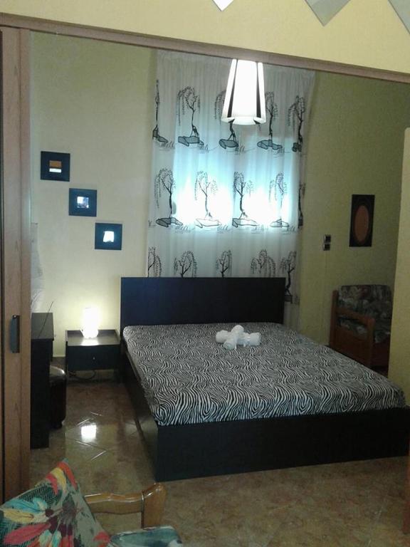 sypialnia z łóżkiem z zasłoną zebrową w obiekcie Gatos Apartment w mieście Skala Marion