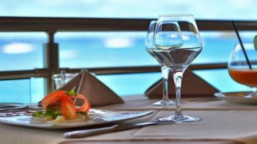 - une table avec une assiette de nourriture et un verre de vin dans l'établissement Marin'a baie Martinique, au Marin