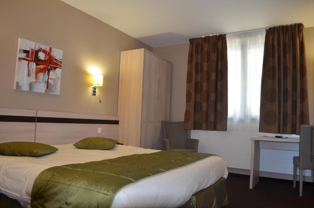 a hotel room with a bed and a window at Park Hôtel & Appartements in Cholet