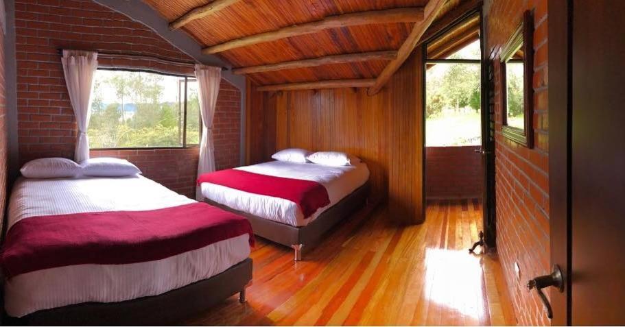 a bedroom with two beds and a brick wall at Chalet la Bonita in El Encano