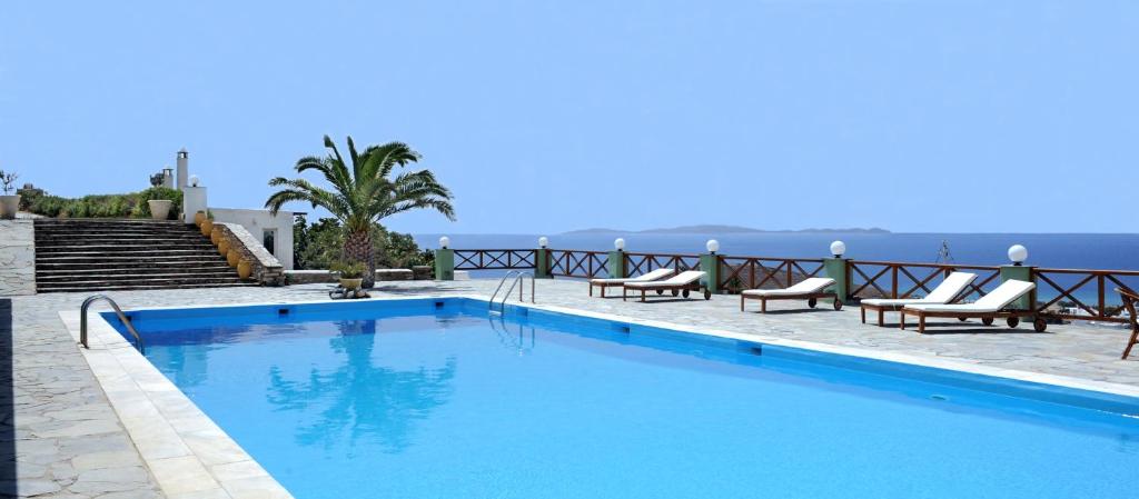 a swimming pool with a view of the ocean at Carlo Bungalows in Agios Ioannis
