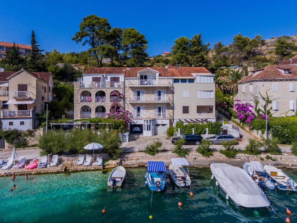 a group of boats in the water in front of buildings at Seaview apartments in Bobovišća