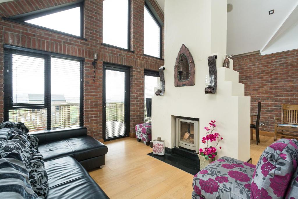 a living room with a couch and a fireplace at Grianan View in Burnfoot