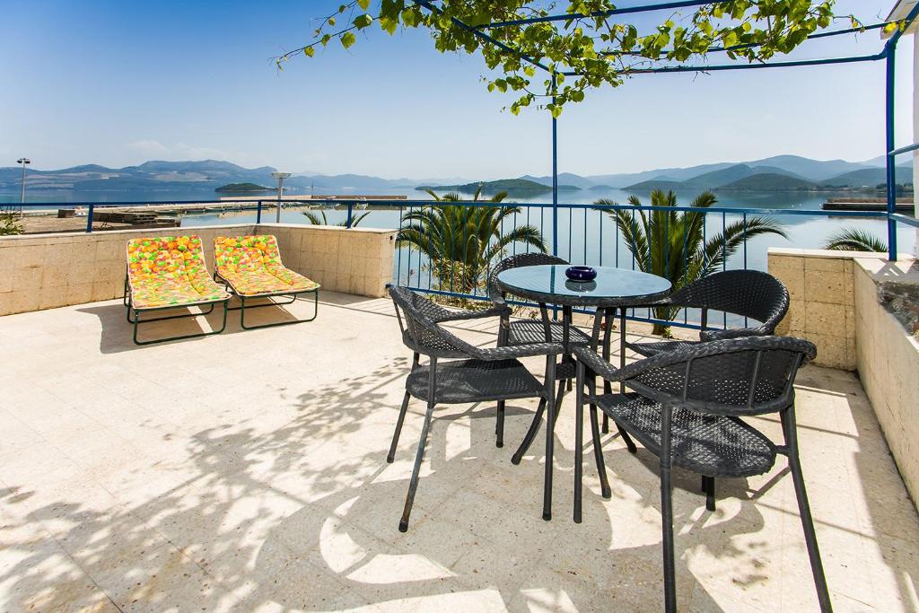 a patio table and chairs with a view of the water at House Kapetan Nono in Drače