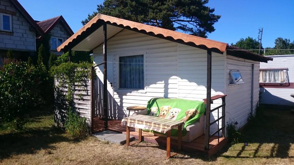 a gazebo with a chair in a yard at DOM BURSZTYNEK -domek drewniany in Junoszyno