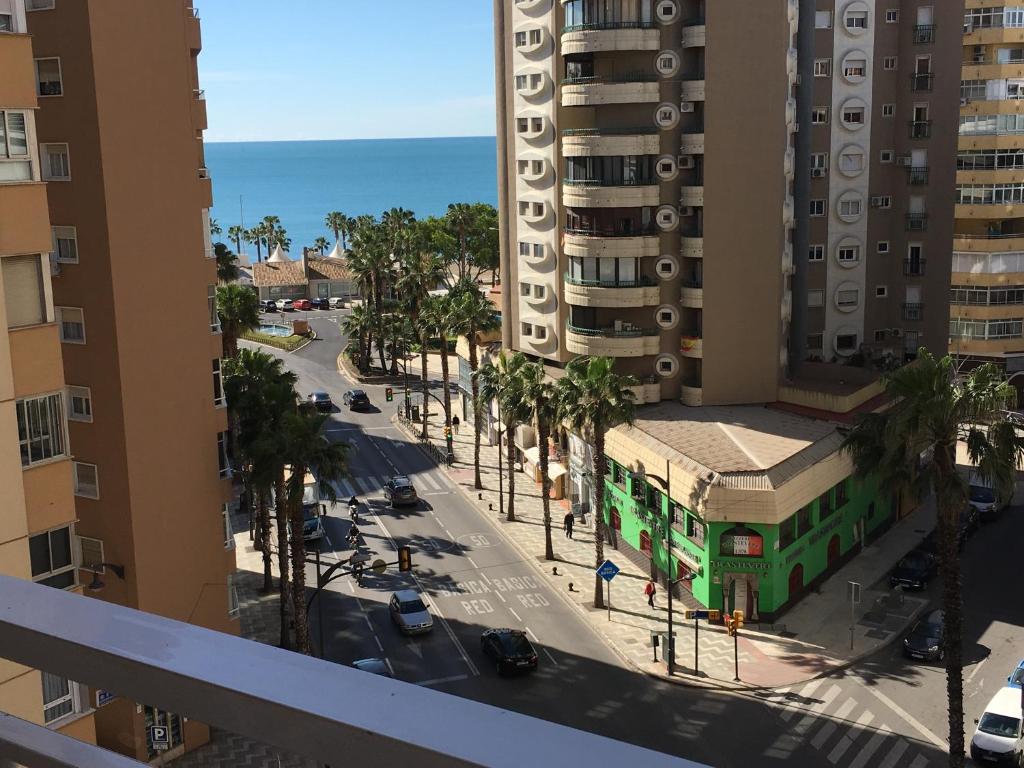 een stadsstraat met een groene bus voor een gebouw bij Malagueta Beach Premium in Málaga
