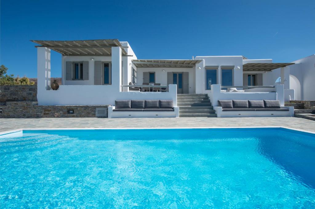 a villa with a swimming pool in front of a house at Aqua in Parasporos