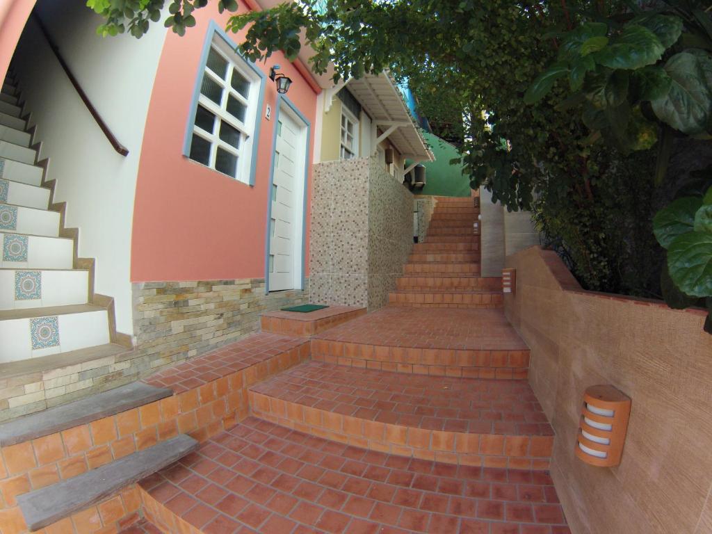 een stenen trap naar een huis met een witte deur bij Casinhas do Morro in Morro de São Paulo