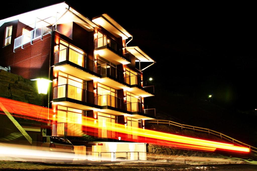 ein Gebäude in der Nacht mit einem vorbeifahrenden Zug in der Unterkunft Hotel Alpenland in Sankt Anton am Arlberg