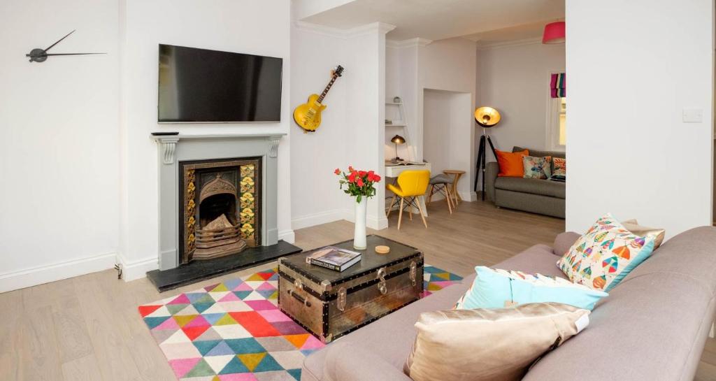 a living room with a couch and a fireplace at Central Regency Town House in Brighton & Hove
