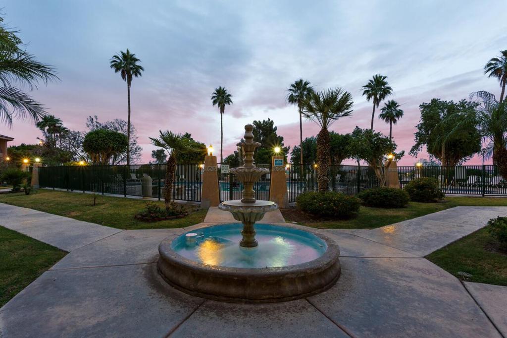 a fountain in the middle of a park with palm trees at Yuma Inn & Suites in Yuma
