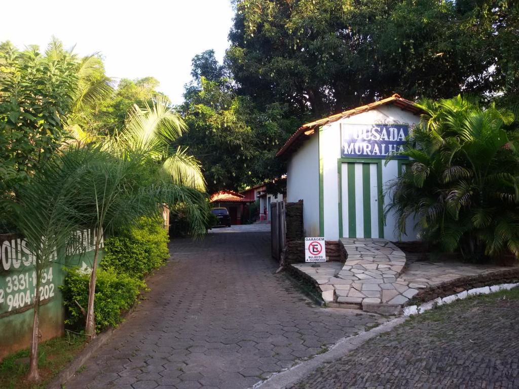 un pequeño edificio blanco con un cartel en él en Pousada Muralha en Pirenópolis