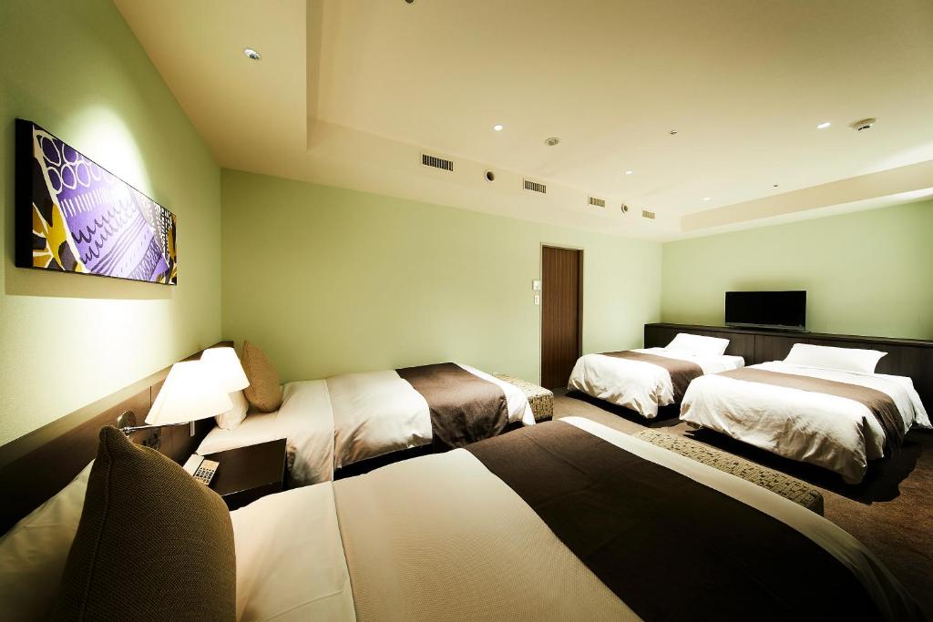 Postel nebo postele na pokoji v ubytování Ginza Grand Hotel