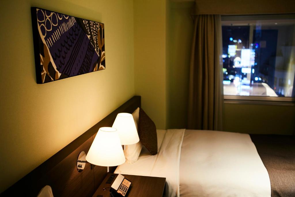 Postel nebo postele na pokoji v ubytování Ginza Grand Hotel