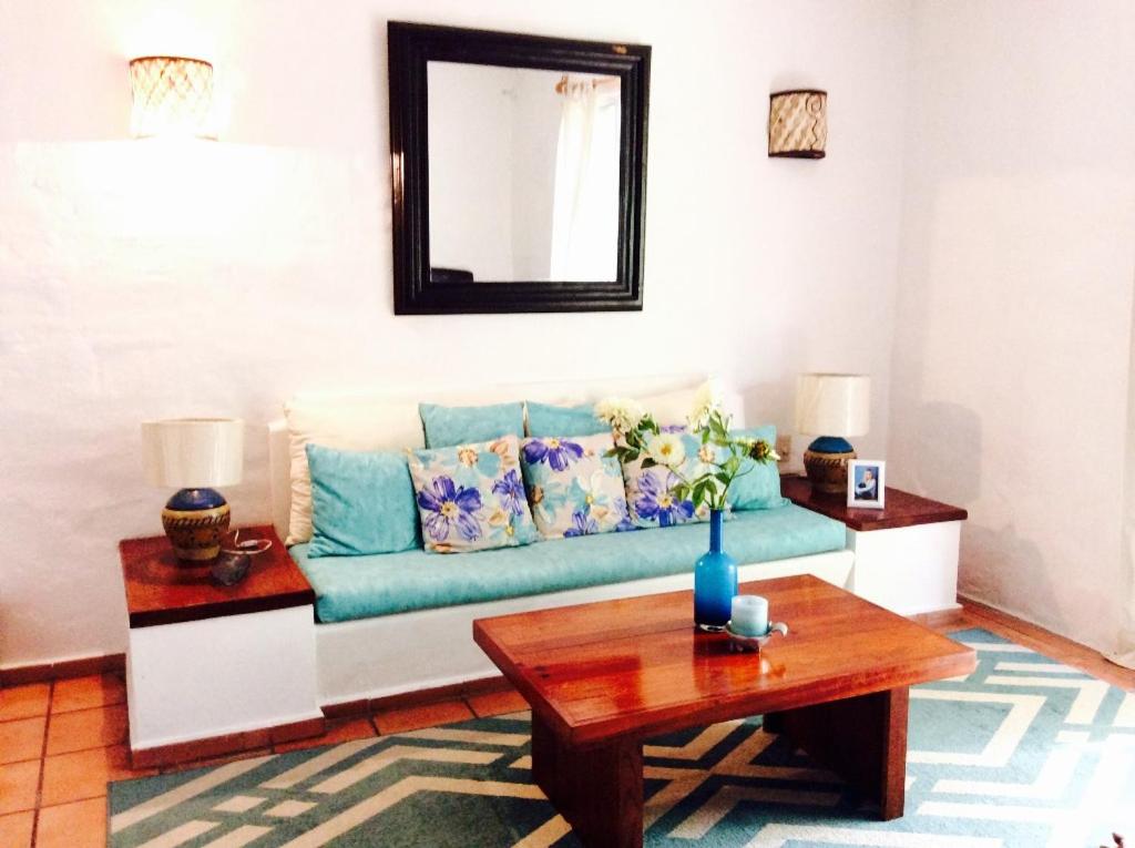 uma sala de estar com um sofá azul e uma mesa em Hermoso departamento a una cuadra de la playa em Puerto Vallarta
