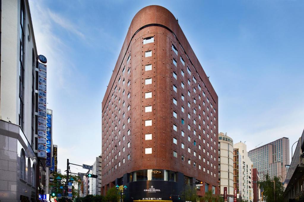 a tall red brick building on a city street at Ginza Grand Hotel in Tokyo