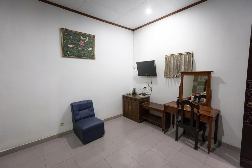 Habitación con escritorio, silla y espejo. en Hotel Lestari en Gilimanuk