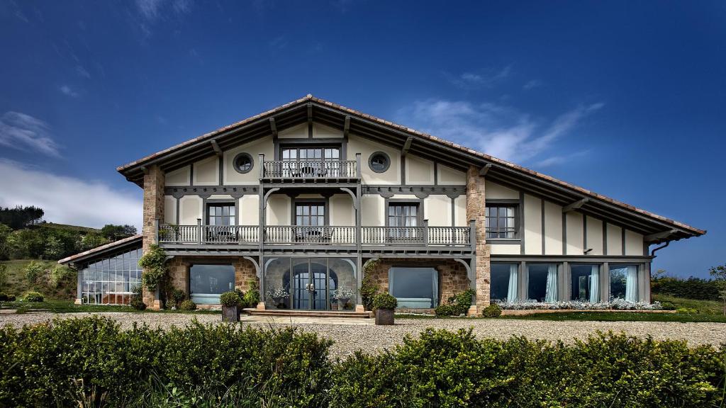 a large white house with a balcony at Hotel Iturregi in Getaria