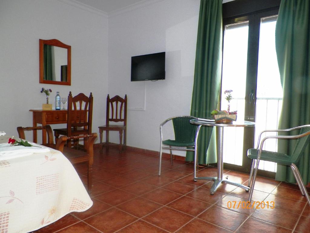 Casa Francisco el de Siempre في إل بلمار: غرفة معيشة مع طاولة وكراسي وتلفزيون