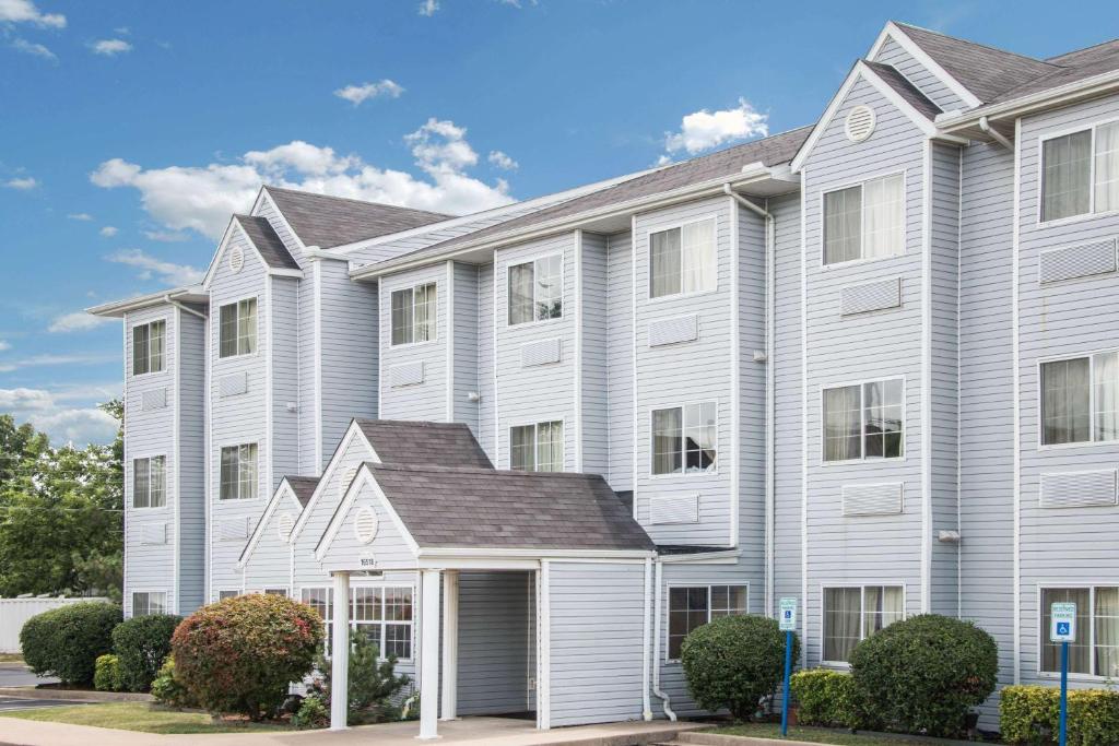 a large apartment building with white at Microtel Inn & Suites by Wyndham Tulsa - Catoosa Route 66 in Tulsa
