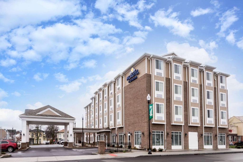 ein großes Gebäude auf einer Straße mit einem Himmel in der Unterkunft Microtel Inn & Suites by Wyndham - Penn Yan in Penn Yan