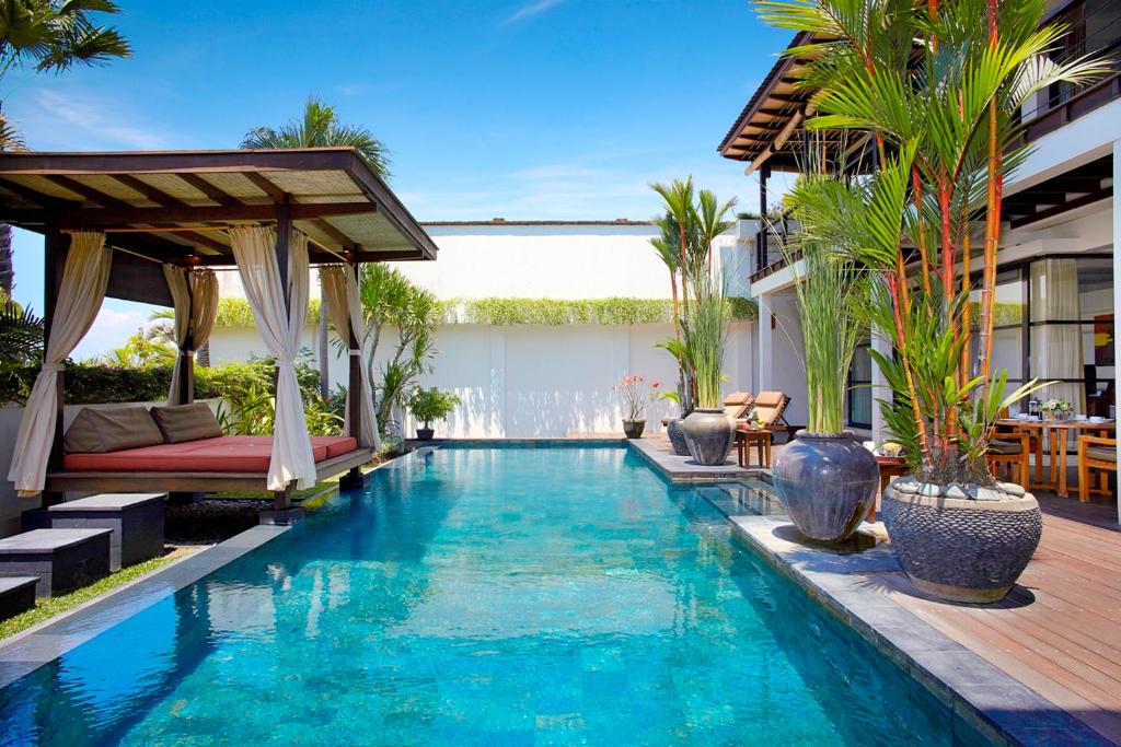 a swimming pool with a patio and a villa at Temple Hill Residence Villa in Jimbaran