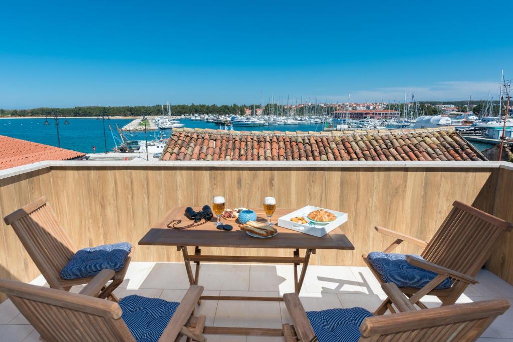 un balcon avec une table et des chaises et un port de plaisance dans l'établissement Skipper Suites, à Novigrad