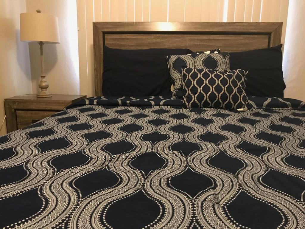 łóżko z czarno-białą kołdrą i poduszkami w obiekcie 1 BEDROOM / 1 BATH . PRIVATE APT. FREE WIFI, INTERENT & PARKING w mieście Sinajana
