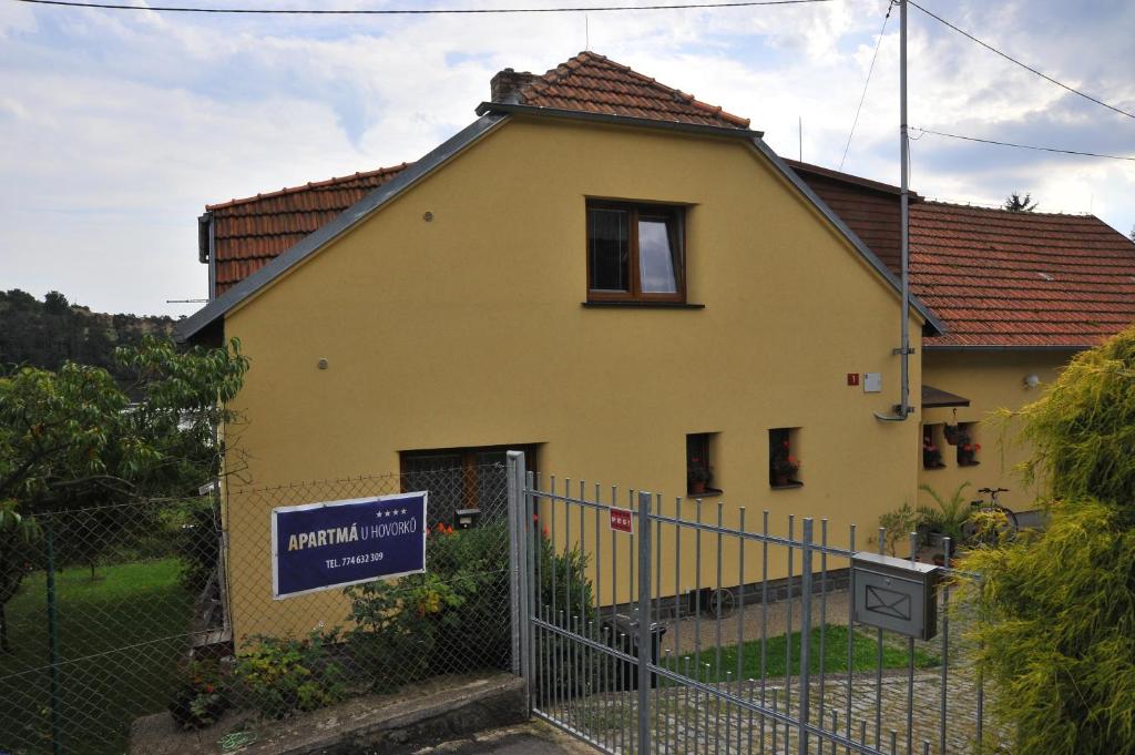una casa amarilla con una valla delante de ella en Apartmá u Hovorků, en Županovice