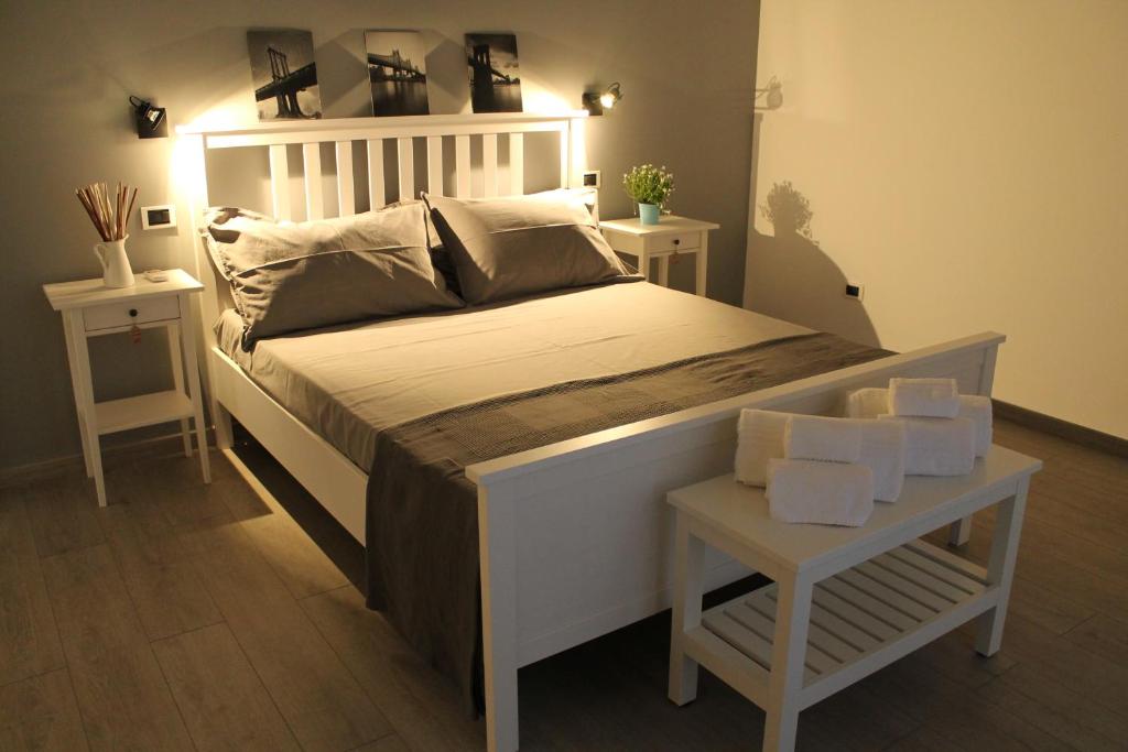 a bedroom with a large white bed and two tables at Casa Mirò in Polignano a Mare