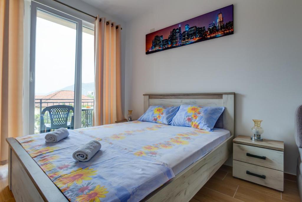 a bedroom with a bed and a large window at Petkovic Accommodation in Tivat