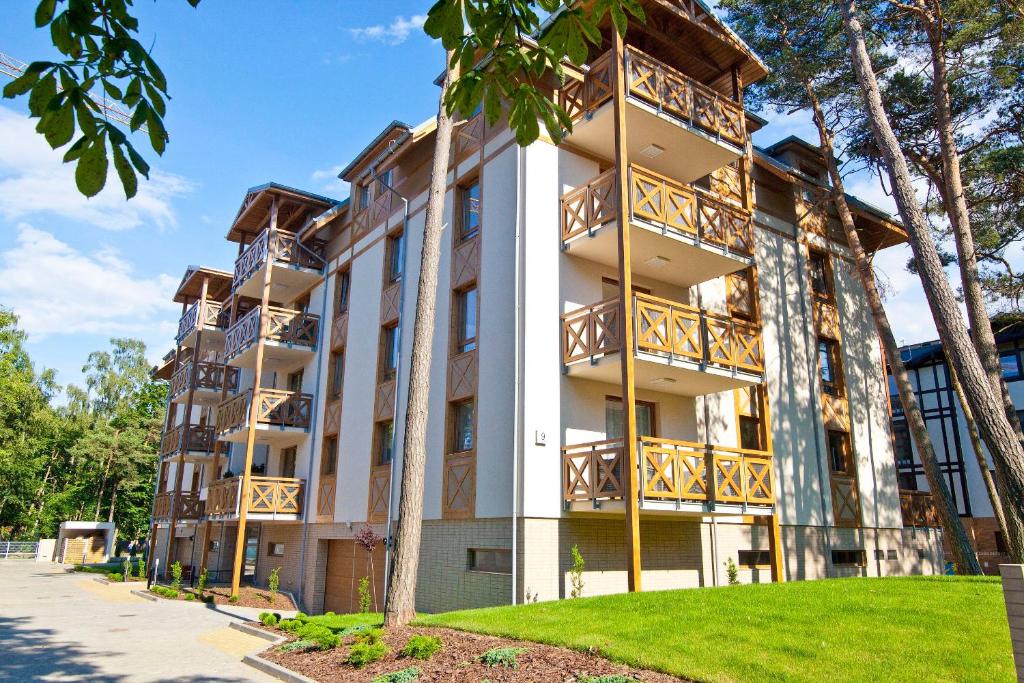 un edificio de apartamentos con balcones y césped en Mi Casa Holidays Rezydencja Park Rodzinna, en Mielno