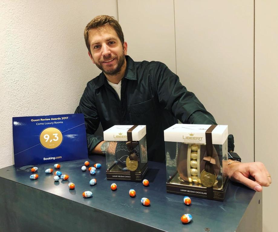 a man sitting at a table with two balls in a box at Como Luxury Rooms in Como