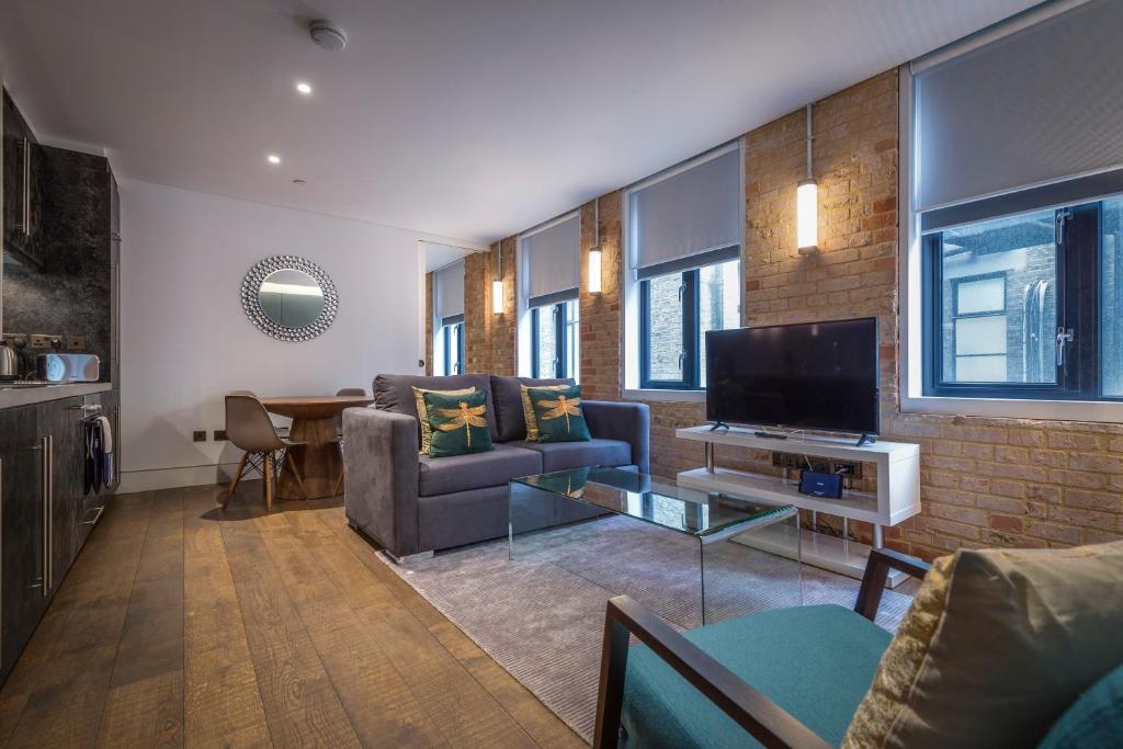 een woonkamer met een bank en een televisie bij Soho One in Londen