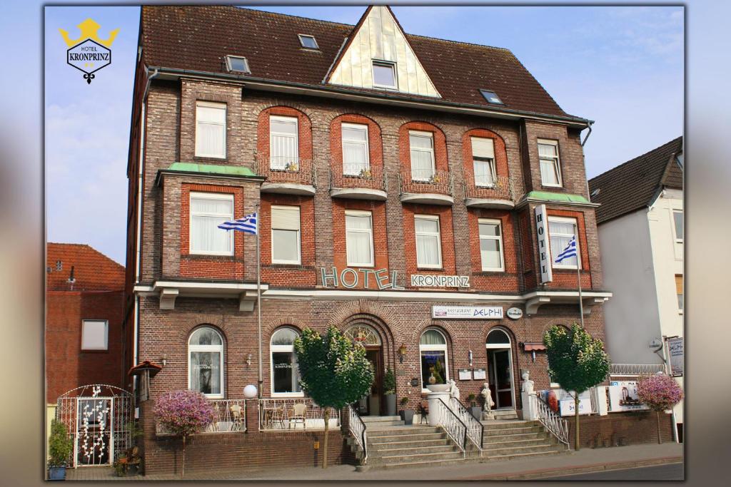 a large red brick building with a hotel at Hotel Kronprinz in Emden