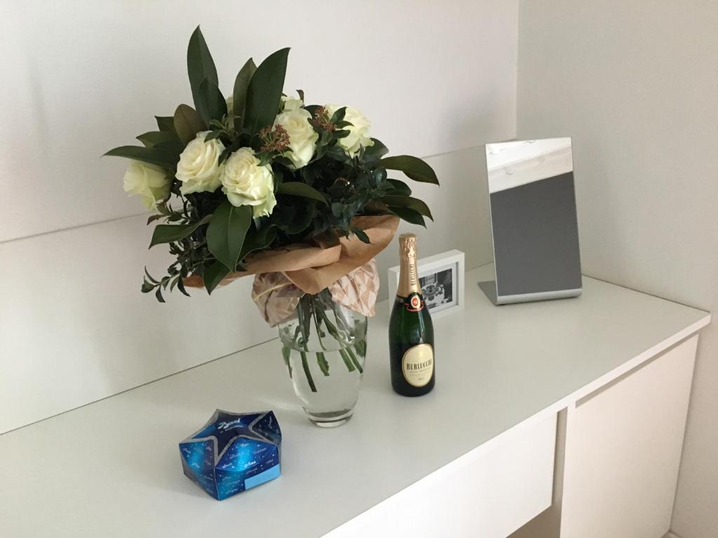 a vase of flowers and a bottle of champagne at Como Luxury Rooms in Como
