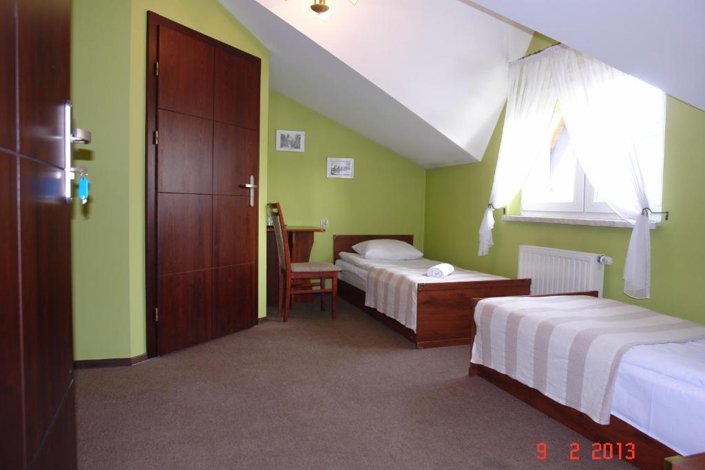 a hotel room with two beds and a window at Pokoje Hotelowe Wiktoria in Goczałkowice Dolne