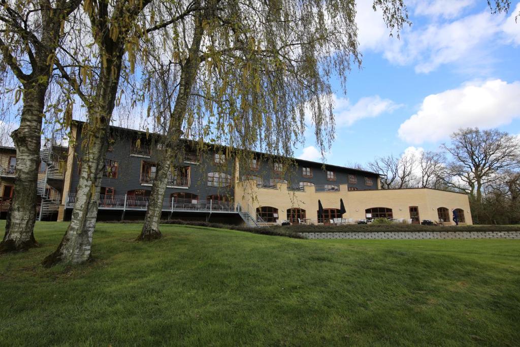 a large building with trees in front of it at Hotel Amerika in Hobro