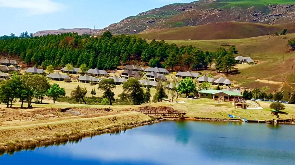 a small village next to a body of water at 124 Fairways Drakensberg Gardens in Underberg
