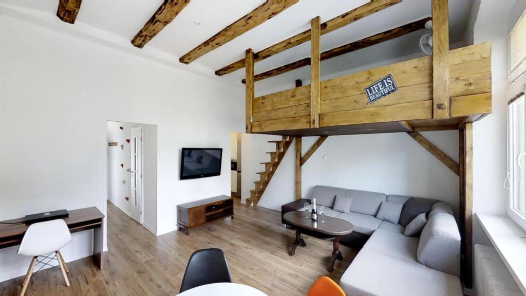 ein Wohnzimmer mit einem Sofa und einem Hochbett in der Unterkunft Old Town Loft in Žilina