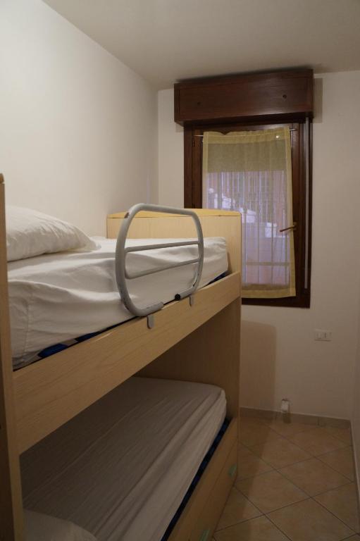 sypialnia z dwoma łóżkami piętrowymi i oknem w obiekcie Residence Corallo w mieście Rosolina Mare