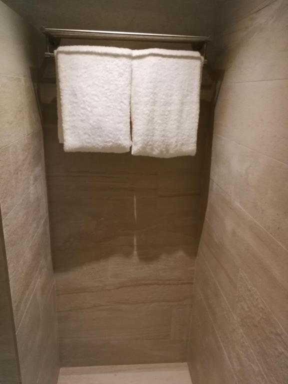 a bathroom with a window and two towels at Cuna Hotel in El Nido
