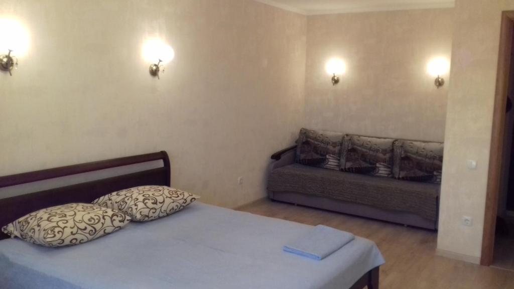 キーウにあるApartment on Rusanivska 16のベッド1台とソファが備わる小さな客室です。